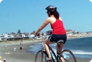 Photo of person biking on the road near the beach
